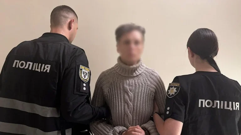 Поліцейські ескортують затриману матір-педофіла під час спецоперації