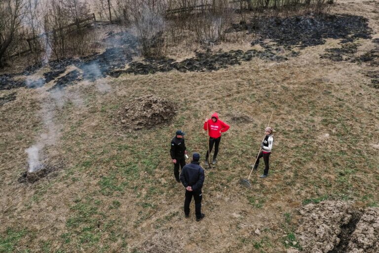 Люди гасять пожежу лопатами на полі в Липчі після удару дронів.