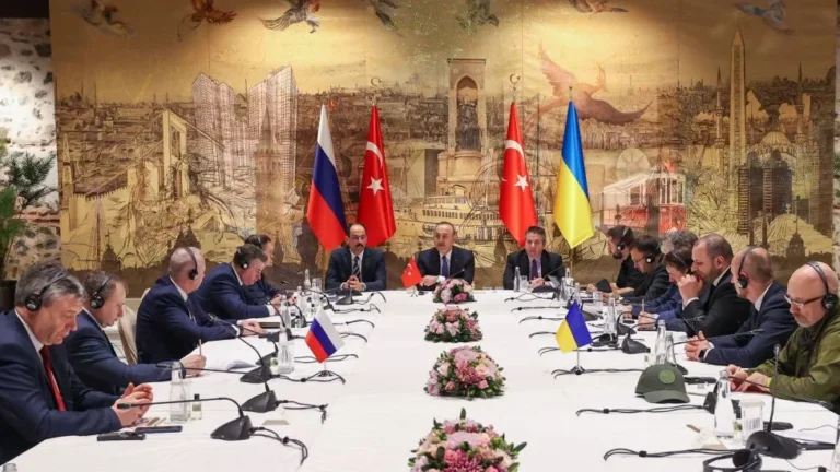 Тристоронні переговори делегацій Росії, Туреччини та України за столом з прапорами.