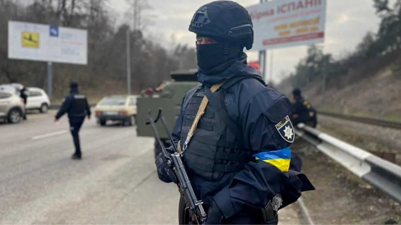 Вооружённые полицейские МВД патрулируют дорогу возле БТР на фронте.