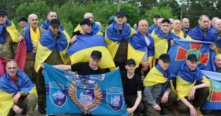 12 захисників МВС після трьох років полону тримають українські прапори та Нацгвардії