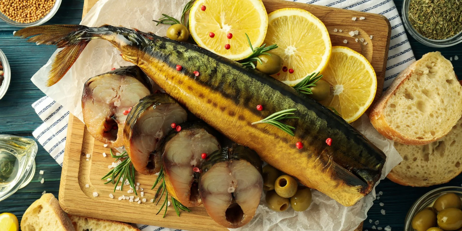 Копчена скумбрія з лимонами, оливками та зеленню на дошці