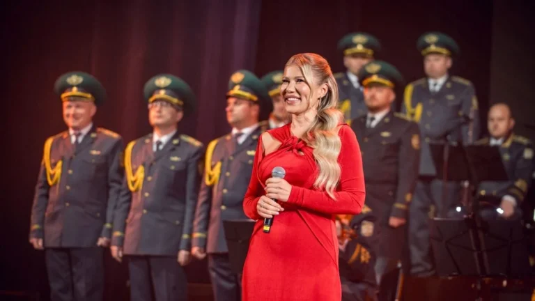 Альона Омаргалієва у червоній сукні співає на концерті для прикордонників
