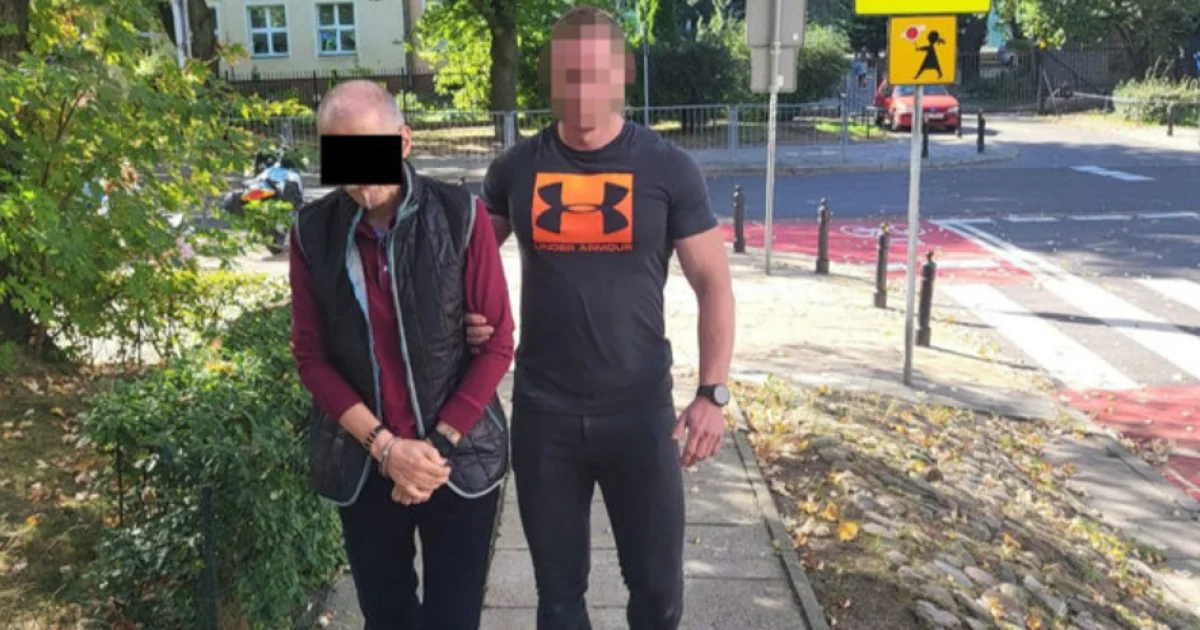 Затриманий Здзіслав М. у наручниках під конвоєм поліцейського