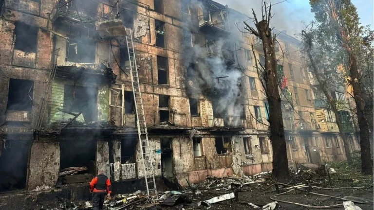 Пожежа в багатоповерхівці Кривого Рогу після російського влучання, рятувальники з драбиною гасять вогонь