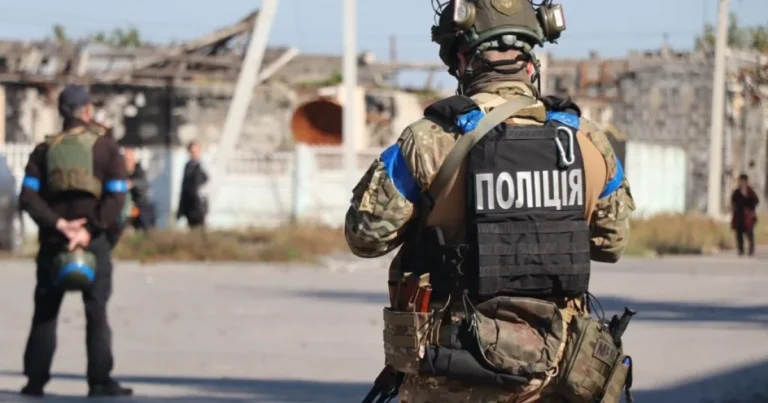 Поліцейський у бронежилеті на тлі зруйнованих будівель у Запоріжжі