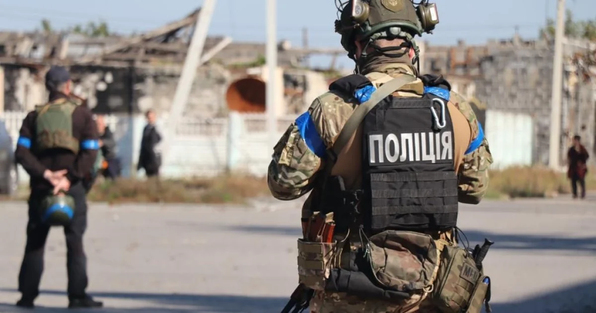Поліцейський у бронежилеті на тлі зруйнованих будівель у Запоріжжі