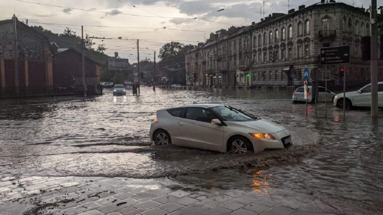 Затоплена вулиця Львова з автомобілем, що пливе по воді під час негоди