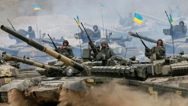 Українські танки з солдатами та прапорами на полі бою