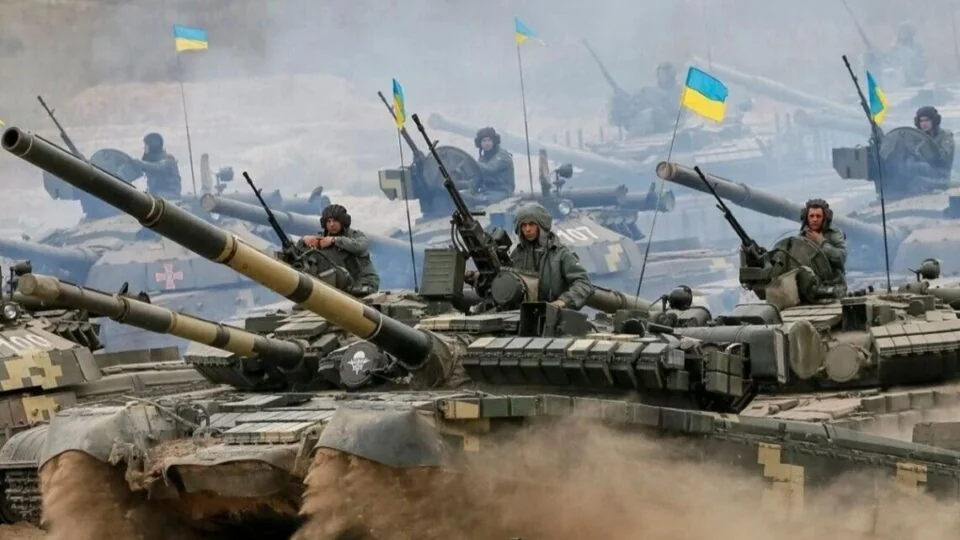 Українські танки з солдатами та прапорами на полі бою