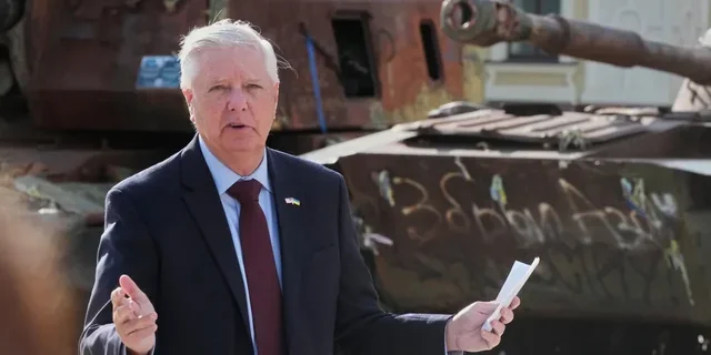 Сенатор Ліндсі Ґрем біля знищеного танка під час візиту до Києва