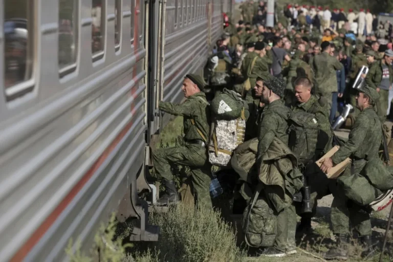 Російські солдати з речами сідають у потяг на мобілізацію