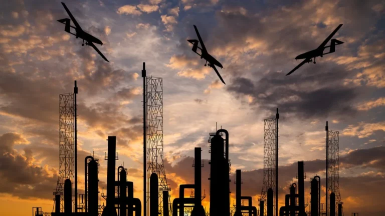 Дрони над силуетом російського нафтопереробного заводу на заході сонця