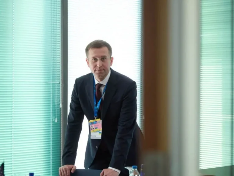 Сергій Корецький у костюмі з бейджем Нафтогазу в офісі