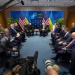 Учасники саміту НАТО за круглим столом з прапорами України та Альянсу