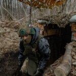 Воїн ЗСУ в замаскованому окопі на позиції в оточенні