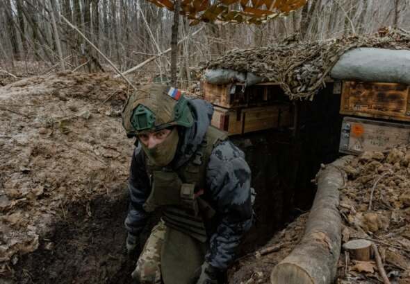 Воїн ЗСУ в замаскованому окопі на позиції в оточенні
