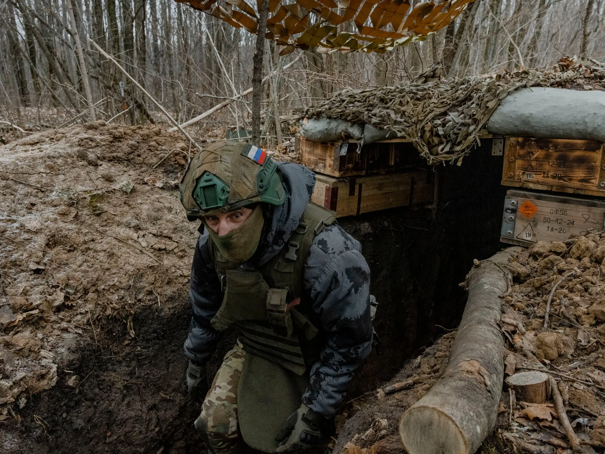 Воїн ЗСУ в замаскованому окопі на позиції в оточенні