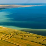 Панорамний аерознімок Кінбурнської коси з піщаним берегом, полями та синьою водою