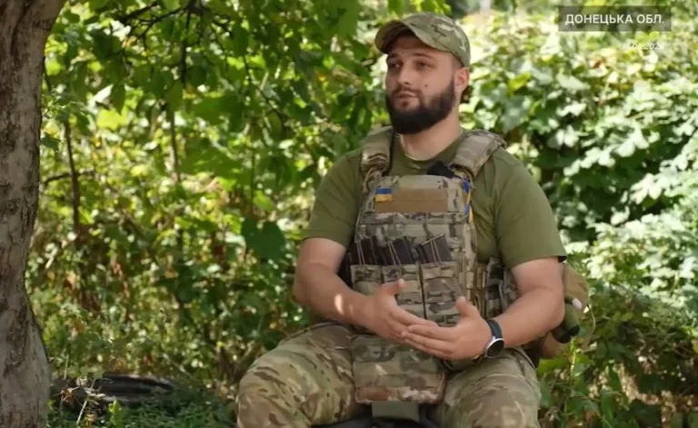 Бойовий медик у камуфляжі та бронежилеті сидить у лісі на Донеччині