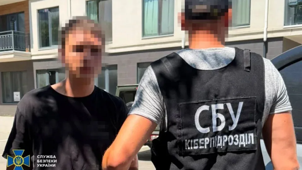 Офіцер кіберпідрозділу СБУ затримує чоловіка в чорній футболці біля будинку