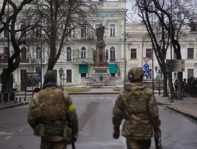 Двое военнослужащих в камуфляже на центральной площади исторического города