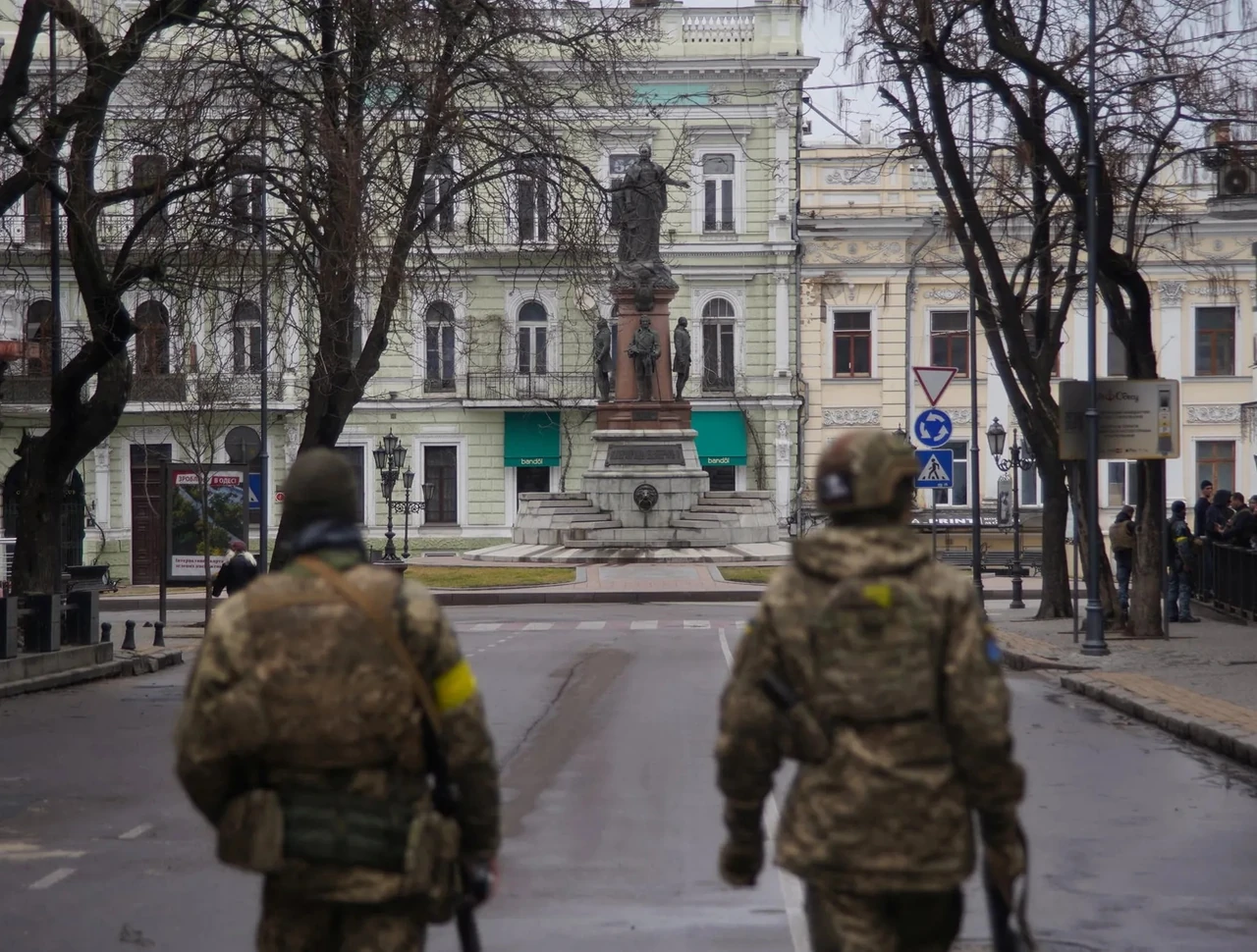Двое военнослужащих в камуфляже на центральной площади исторического города