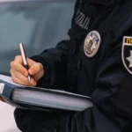 Поліцейський офіцер заповнює документ під час операції