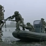 Військові в камуфляжі біля надувного човна на річці в тумані
