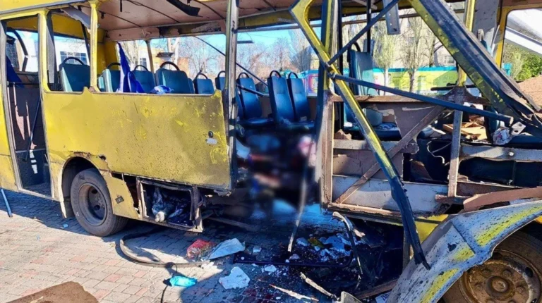 Пошкоджений жовтий рейсовий автобус із розірваним передком і уламками на бруківці