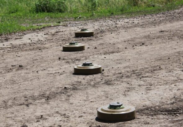 Чотири протитанкові міни викладені на ґрунтовій дорозі біля трави