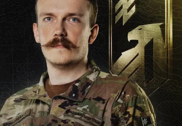 Денис Прокопенко в камуфляжі Нацгвардії на тлі золотої емблеми Азову