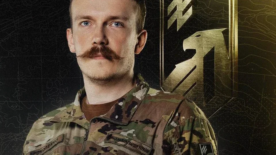 Денис Прокопенко в камуфляжі Нацгвардії на тлі золотої емблеми Азову