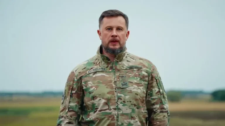Андрій Білецький у камуфляжі стоїть на полі під похмурим небом