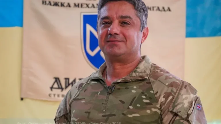 Медик Хосро в камуфляжі на тлі банера бригади Дике Поле