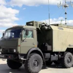 Зелений КамАЗ із броньованим кузовом і антеною РЕБ на виставці