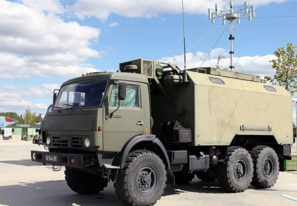 Зелений КамАЗ із броньованим кузовом і антеною РЕБ на виставці