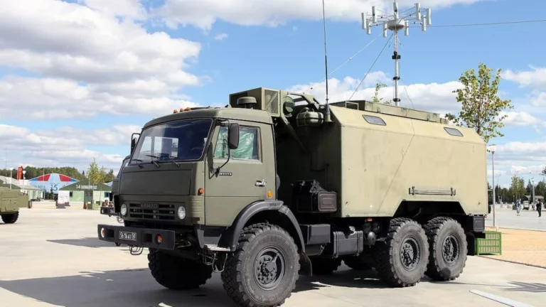 Зелений КамАЗ із броньованим кузовом і антеною РЕБ на виставці